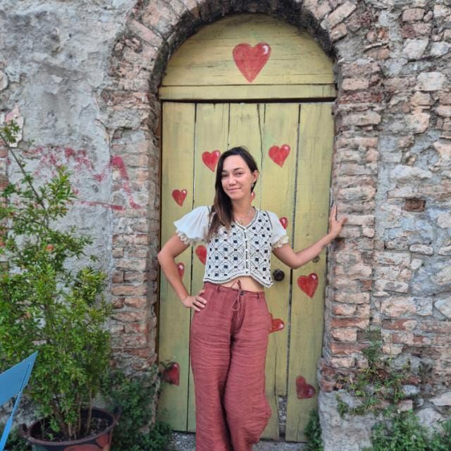 Elisa Marconcini davanti a una porta con cuori dipinti – Lunigiana Toscana